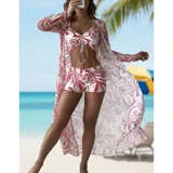 Conjunto de traje de baño de tres piezas con estampado de hojas tropicales en tonos blanco y negro. Incluye un top tipo tankini con cordón ajustable en el centro, un short de tiro alto y una camisa abierta de manga larga tipo salida de baño.