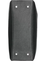 Cartera tipo satchel de Calvin Klein en color negro, confeccionada en material sintético con textura granulada. Presenta doble asa de mano, correa de hombro ajustable y extraíble, y cierre superior con cremallera. Incluye accesorios colgantes decorativos: un monedero circular y un pequeño estuche con solapa, ambos con el monograma de la marca.