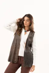 Chaleco de cuero marrón con silueta relajada, caracterizado por detalles de ojalillos metálicos a lo largo de los bordes frontales.