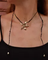 Collar tipo gargantilla con dije de flor metálica de acabado brillante, suspendido de un cordón doble de seda natural teñido a mano en color rojo.