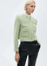 Chaqueta de tweed en color verde claro, con cuello redondo, cierre frontal con cremallera y cuatro bolsillos de parche delanteros con bordes deshilachados.
