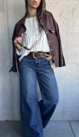 Blusa oversize de color blanco con diseño romántico y bohemio, confeccionada con detalles de encaje y botones forrados en el frente. Cuenta con mangas largas.
