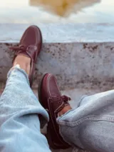 Mocasines náuticos color borgoña de cuero con cordones y suela marrón.