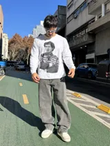 Pantalón de jean con corte baggy y diseño balloon, de color gris lavado con efecto desgastado. Presenta costuras laterales curvadas y una silueta amplia y holgada.