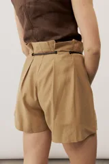 Short blanco de tiro alto, confeccionado en lino, con bolsillos laterales y cordón ajustable en la cintura.