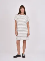 Vestido corto de manga corta, color blanco con rayas horizontales negras, cuello redondo y corte holgado.