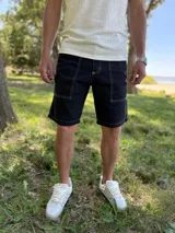 Bermuda de jean gris claro con efecto acid wash, bolsillos delanteros aplicados y costuras destacadas.
