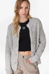 Cardigan tejido de punto gris, de corte relajado, con cuello redondo y cierre frontal de botones.