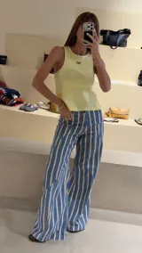 Jeans wide leg de tiro medio con patrón de rayas verticales en tonos azul y beige, con recortes y pespuntes a contratono.