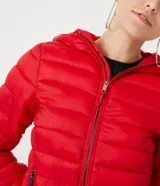 Campera puffer roja, ligera, de poliamida, con capucha y bolsillos con cremallera. Incluye bolsa para guardarla.
