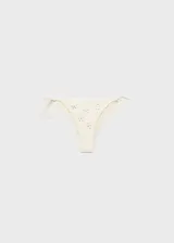 Traje de baño de dos piezas color blanco, con apliques metálicos y cierre de lazos ajustables.
