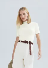 Blusa marrón de manga corta y cuello alto, confeccionada en tejido acanalado de ajuste ceñido al cuerpo.