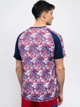 Remera de fútbol Umbro del Club Nacional de Football, modelo Pro Training Active. Diseño con estampado abstracto en blanco, rojo y azul, con mangas raglán azul marino y escudo del club en el pecho.