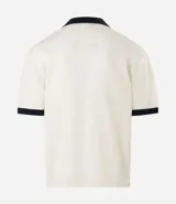 Remera de punto con textura calada, corte boxy y cuello polo en contraste. Presenta escote en V, mangas cortas con terminación en contraste y bordados decorativos en el pecho.
