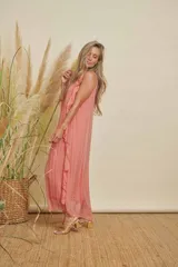 Vestido largo color rosado, sin mangas, con detalles de volados en cascada a lo largo del frente y diseño holgado.