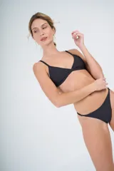 Conjunto de bikini negro con corpiño triangular con tiras largas para atar en la cintura y bombacha colaless con tiras para atar en los costados.