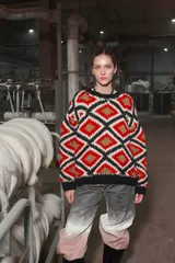 Sweater tejido de lana con diseño geométrico de rombos en colores rojo, blanco, negro y dorado.