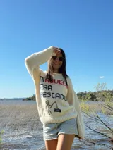 Sweater color crema tejido a mano en lana merino, con cuello redondo y diseño bordado con la frase "Mi abuelo era pescador" y un dibujo de una persona pescando.