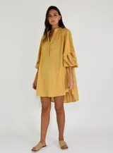 Vestido corto amarillo con cuello mao, mangas 3/4 con detalle de calado y corte evasé.