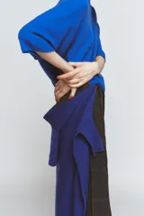 Jersey de punto liso color azul eléctrico, con cuello redondo y mangas anchas de corte caído.