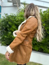 Tapado marrón con interior de corderito blanco, cierre frontal con cremallera, bolsillos laterales con cremallera, detalles acolchados en los hombros y puños con corderito.