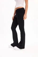 Pantalón calza gris melange de corte flare, tiro alto con cintura rebatible ancha y ajuste entallado en las piernas que se ensancha hacia los tobillos.