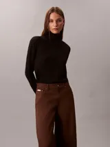 Pantalón chino de pierna súper ancha color marrón, tiro alto, con diseño de cinco bolsillos, cierre de botón y cremallera, y detalles distintivos de la marca Calvin Klein.