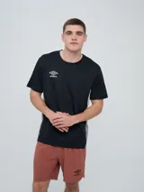 Remera deportiva Umbro modelo Vant, de color negro con paneles laterales grises y cuello redondo, diseñada para hombre.