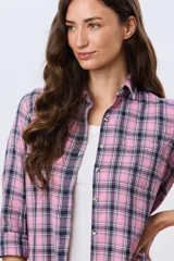 Camisa holgada a cuadros en tonos rosado, azul marino y blanco, de manga larga con puños ajustables, cuello camisero y cierre frontal de botones.