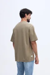 Remera de manga corta color verde militar con textura sutil y pequeña estampa discreta en el pecho.