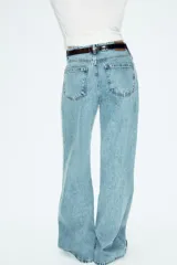 Jeans de tiro alto con diseño wide leg y cinco bolsillos. Presenta cierre frontal con cremallera y botón, e incluye un cinturón a contraste con hebilla metálica.