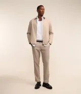 Pantalón de vestir color beige con estampa de cuadros en hilo teñido, corte slim, cintura con trabillas, cierre con botón y cremallera, bolsillos laterales y traseros.