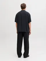 Camisa negra de manga corta con cuello cubano y cierre frontal con botones.