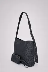 Bolso tipo hobo con estampado animal print en tonos negros, confeccionado en material sintético. Cuenta con una correa larga regulable, cierre superior y un mini monedero desmontable a juego.
