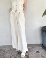 Pantalón de vestir color beige, de corte palazzo y tiro alto.