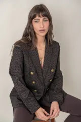 Blazer marrón con estampado animal print en negro, doble botonadura dorada y bolsillos con solapa.