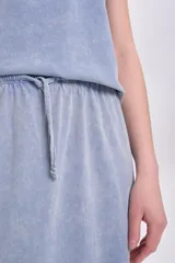 Falda midi celeste con efecto lavado, corte recto y abertura lateral.