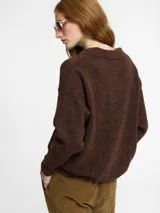 Sweater de punto color rosado, con cuello polo y escote en V. Tiene manga larga con puños ajustados y ruedo en punto ajustado.