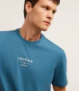 Remera celeste de algodón con cuello redondo y mangas cortas. Estampa frontal con la palabra "VELEJAR" y otros textos en blanco.