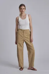 Pantalón color beige con tachas plateadas, tiro alto y corte recto.