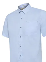 Camisa de lino orgánico color celeste de manga corta, con cuello camisero, cierre frontal de botones, bolsillo en el pecho con logo bordado y calce regular.