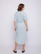 Vestido camisero midi azul con estampado floral blanco, corte recto, cuello camisero, mangas cortas, bolsillos laterales y lazo ajustable en la cintura.