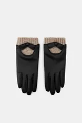 Guantes cortos combinados de efecto piel en color negro, con detalle de tejido de lana en tono beige en la muñeca y cierre con botón a presión.