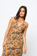 Vestido largo color ocre con estampado floral, escote en V y espalda descubierta.