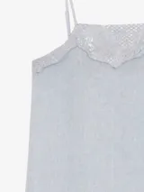 Vestido largo celeste de lino, de silueta recta y finos breteles regulables, con detalles de encaje aplicado en el escote y en el ruedo asimétrico.