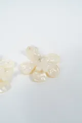 Aros colgantes con diseño de flor en material acrílico con efecto nacarado.