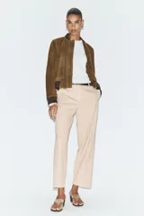 Pantalón tobillero de corte recto en color beige, con detalle de nervio delantero marcado. Incluye cinturón fino, bolsillos delanteros y cierre frontal con cremallera, botón interior y gancho.