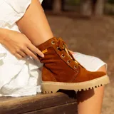 Bota acordonada color marrón óxido, de cuero gamuzado, con suela track color beige.