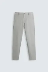 Pantalón slim fit de tejido elástico color gris, con cintura elástica, cierre frontal con cremallera y botón, bolsillos laterales y bolsillos traseros de vivo.