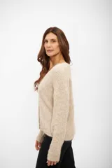 Saco tipo cardigan de tejido de punto en color beige, con escote en V, cierre frontal con botones y mangas largas.